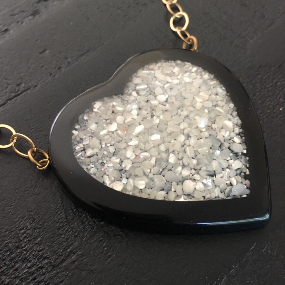 Black heart necklace on gold medal link chain.